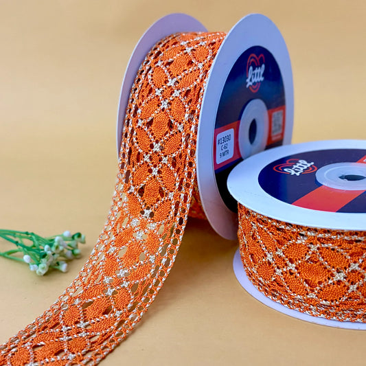 Orange lace ribbon on spools with a visible brand label against a beige background