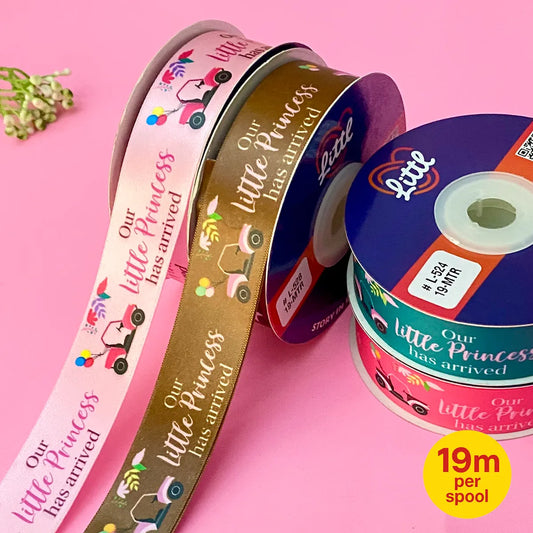 Three spools of ribbon with 'Our little Princess has arrived' text on a pink background