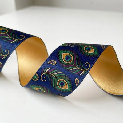 Close-up of Mor Pankh ribbon: peacock feathers in green, teal and gold printed on navy blue satin