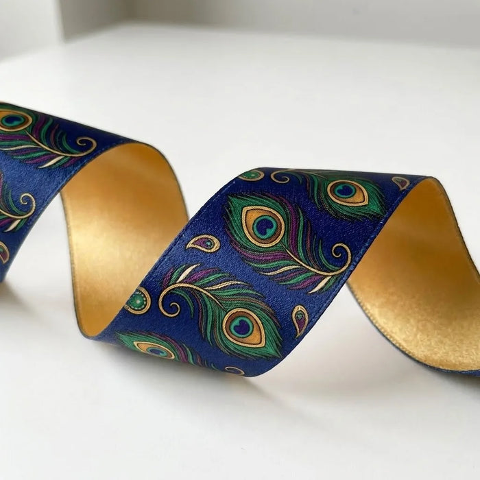 Close-up of Mor Pankh ribbon: peacock feathers in green, teal and gold printed on navy blue satin