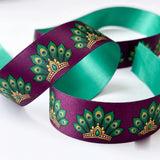 Close-up of Peacock Fan ribbon: emerald peacock fans with gold printed on plum purple satin