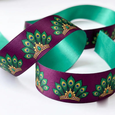 Close-up of Peacock Fan ribbon: emerald peacock fans with gold printed on plum purple satin