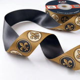 Close-up of Fleur-de-Lis ribbon: black and gold fleur-de-lis medallions printed on bronze gold satin
