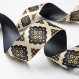 Close-up of Damask Tile ribbon: black and gold damask tiles printed on cream satin