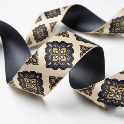 Close-up of Damask Tile ribbon: black and gold damask tiles printed on cream satin