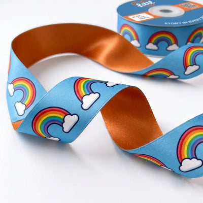 Close-up of Rainbow Clouds ribbon: rainbows and white clouds printed on sky blue satin