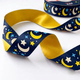 Close-up of Moon & Stars ribbon: golden moons and stars printed on midnight navy satin