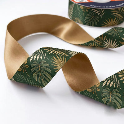 Close-up of Palm House ribbon: gold-lined palm and monstera leaves printed on forest green satin