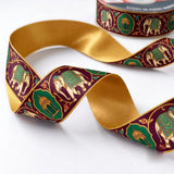 Close-up of Elephant Darbar ribbon: royal elephants and arch medallions printed on maroon satin