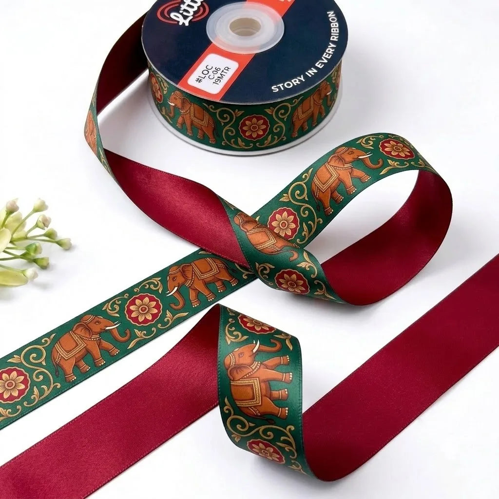 Elephant Mela ribbon twisted to show the printed front and solid crimson red back
