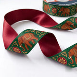 Close-up of Elephant Mela ribbon: red elephants and florals printed on emerald green satin