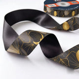 Close-up of Ginkgo Noir ribbon: gold-lined ginkgo leaves printed on charcoal satin