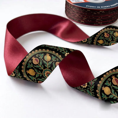 Close-up of Paisley Jaal ribbon: gold and green paisley jaal printed on black satin