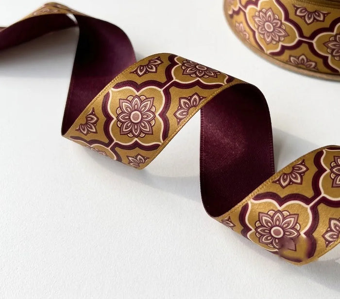 Close-up of Jaali Medallion ribbon: maroon floral jaali medallions printed on gold satin