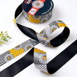 Daisy Patchwork ribbon twisted to show the printed front and solid black back