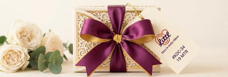 Wedding favour box tied with a plum and gold dual tone satin ribbon bow